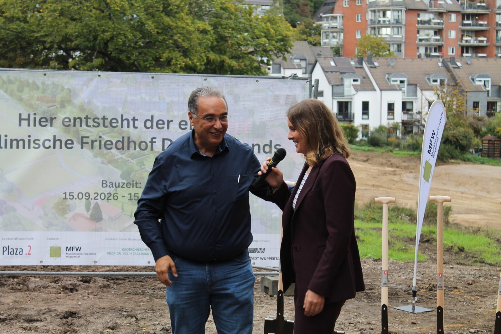 Samir Bouaissa im Gespräch mit Oberbürgermeisterin Miriam Scherff vor dem Bauschild beim Spatenstich