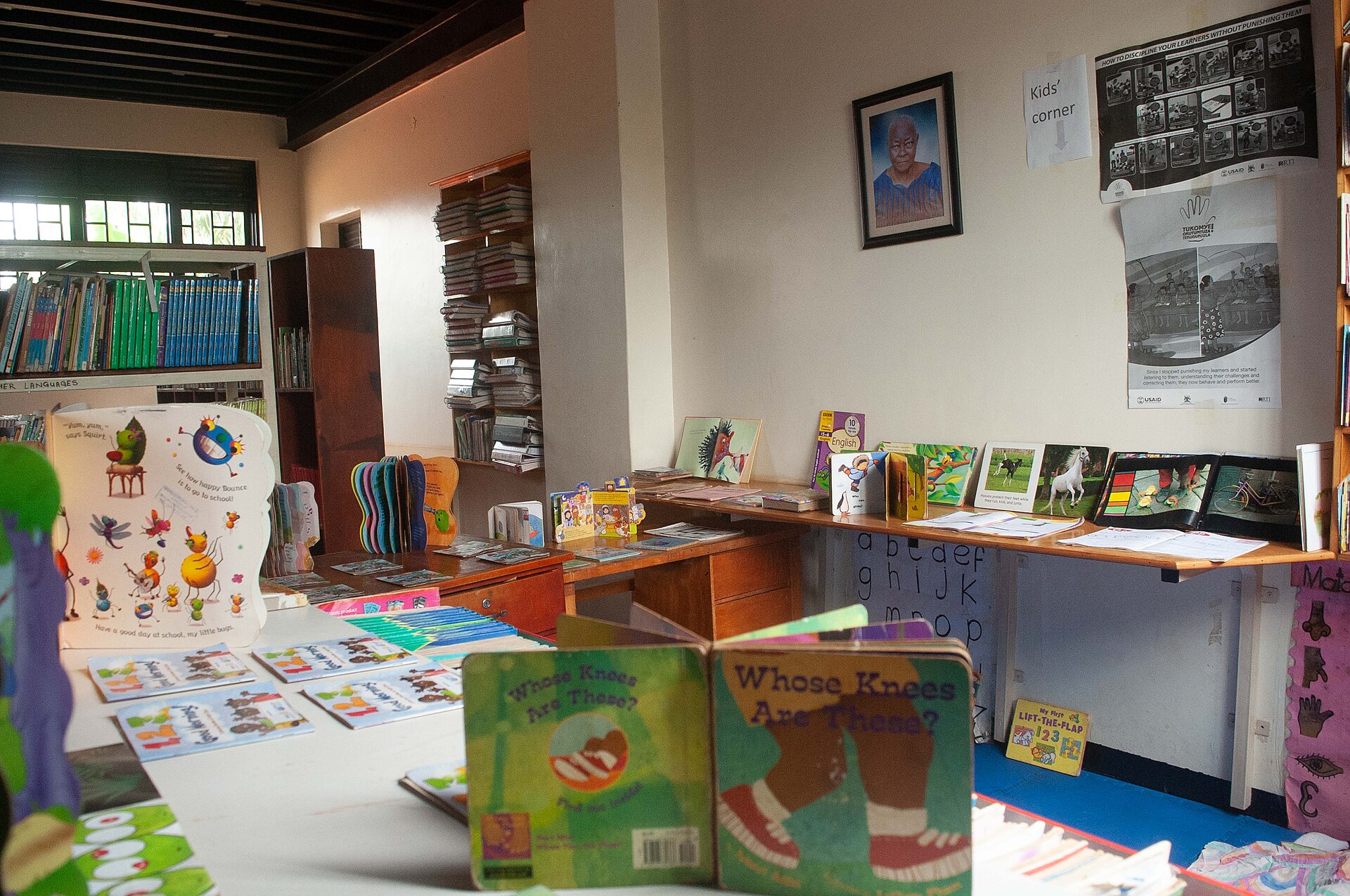 Leseecke einer Gemeindebibliothek mit Kinderbüchern auf Tischen und Regalen