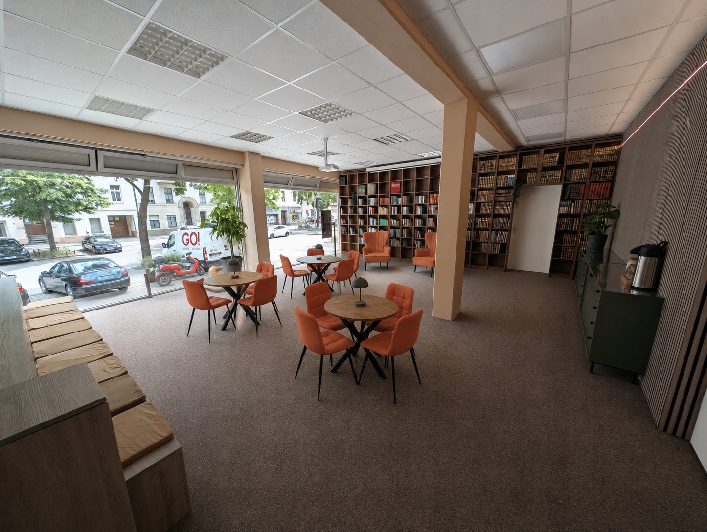 Lesecafé des Hikma-Zentrums in Berlin-Charlottenburg mit Bücherregalen, Tischen und orangefarbenen Sesseln