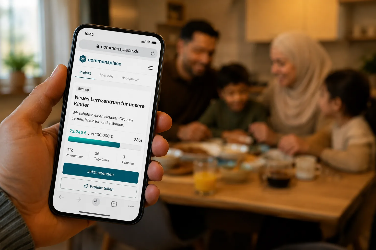 Hand hält ein Smartphone mit einer laufenden Sammlung auf commonsplace, im Hintergrund unscharf eine Familie am Esstisch