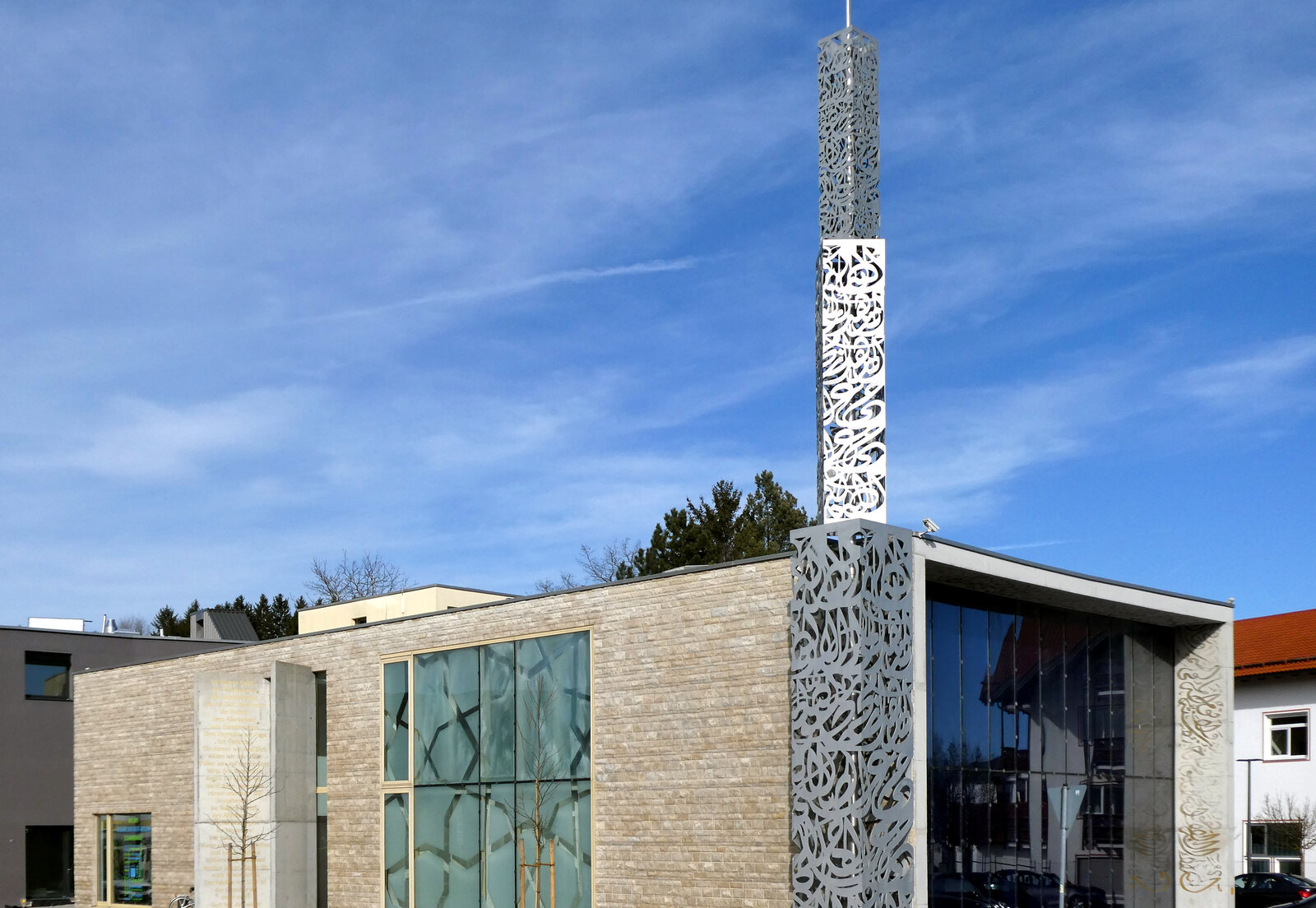 Das Islamische Zentrum Penzberg von außen, ein flacher Bau aus hellem Stein mit einem durchbrochenen Minarett