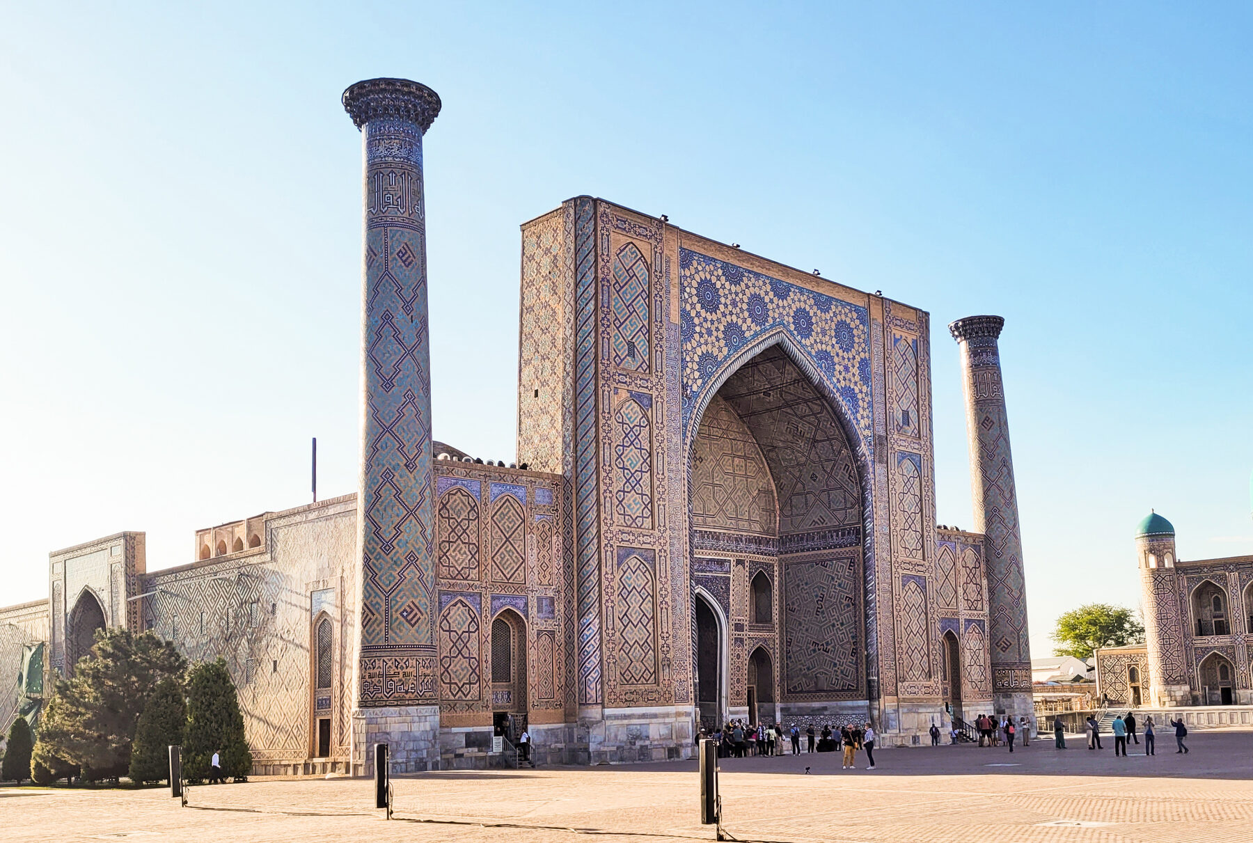 Fassade der Ulugh-Beg-Madrasa am Registan in Samarkand mit großem Portalbogen, blauen Fliesen und zwei Minaretten