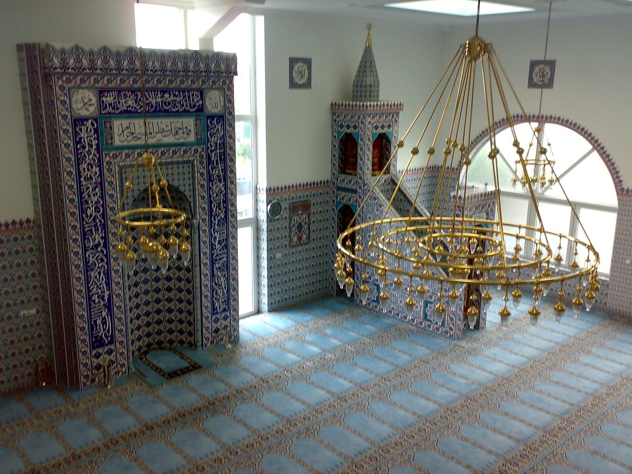 Gebetsraum einer Moschee in Köln-Chorweiler mit Mihrab, Minbar und Teppich